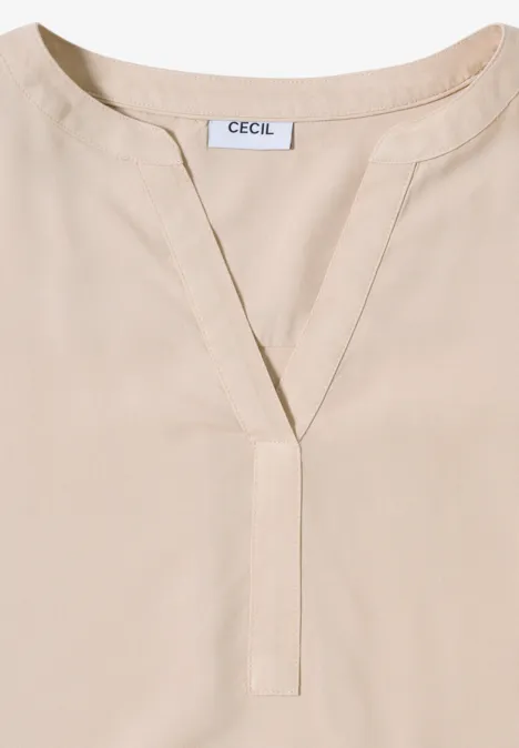Beiges Oberteil mit V-Ausschnitt und Cecil-Etikett am Kragen.
